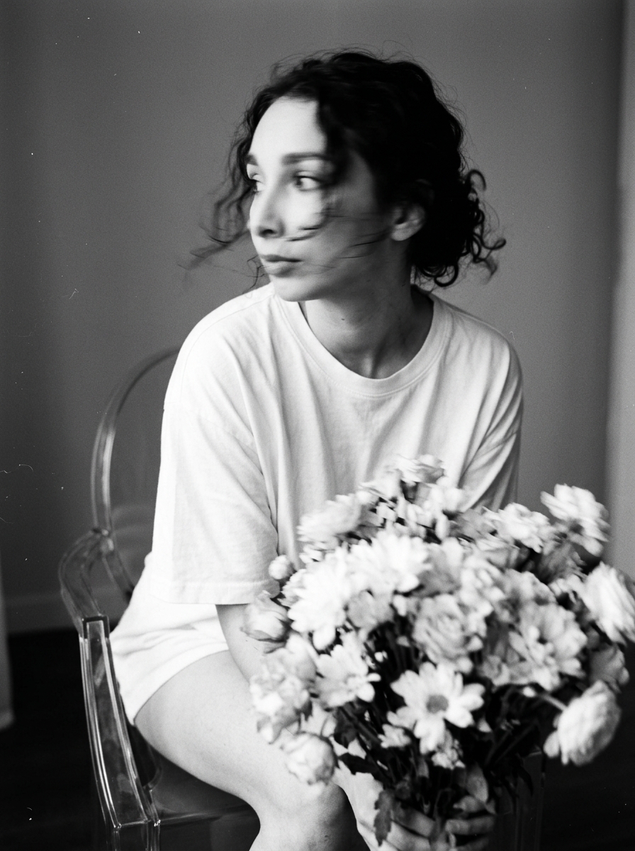 Чёрно-белый портрет девушки с букетом на прозрачном стуле