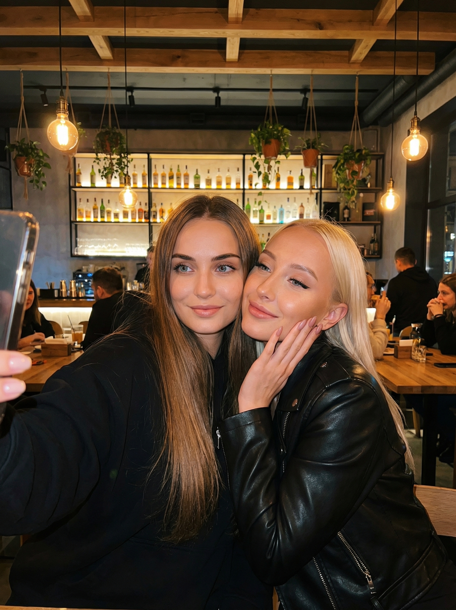 Две подруги делают селфи в современном баре