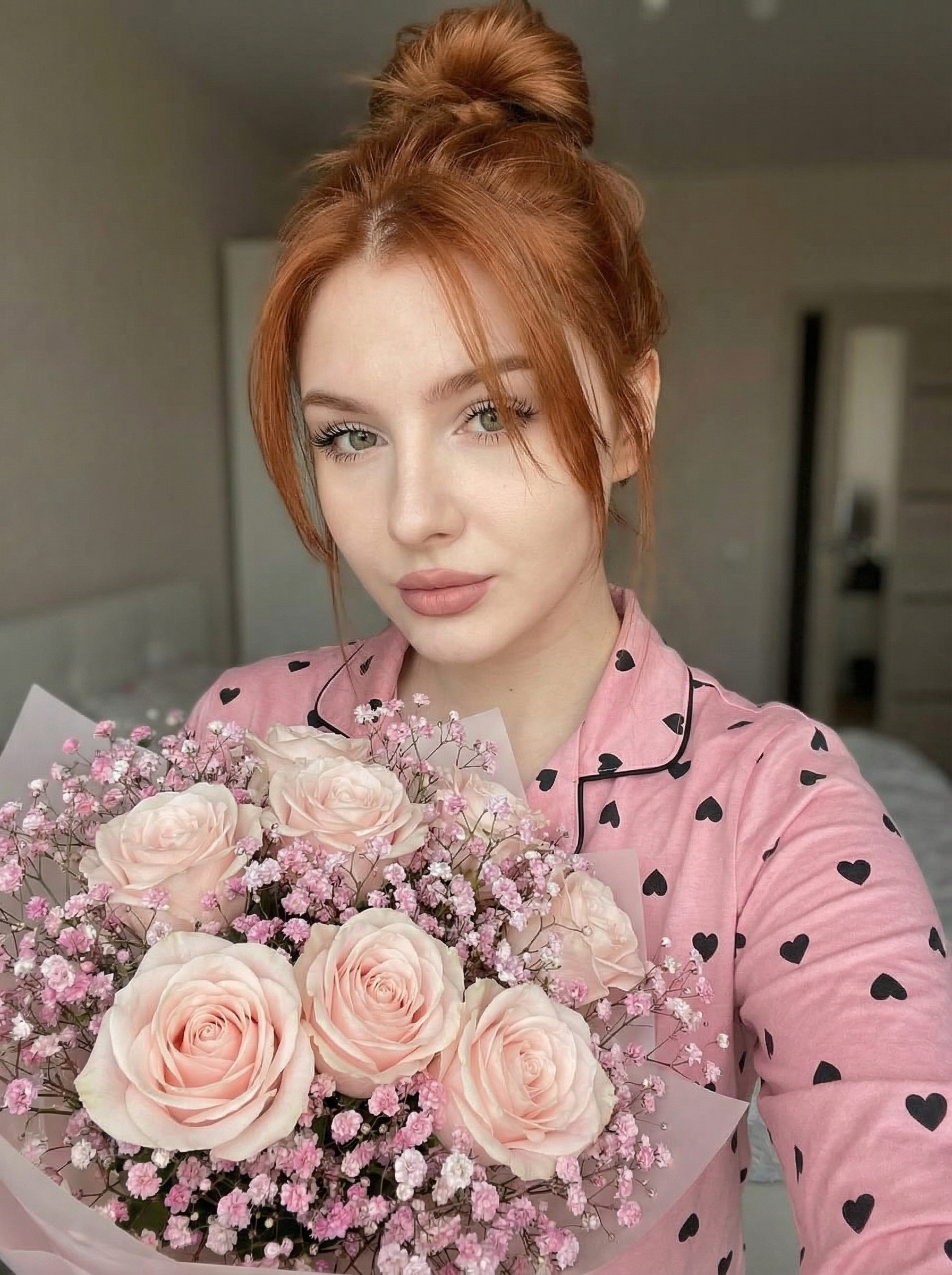 Селфи девушки с букетом в розовой пижаме с сердечками
