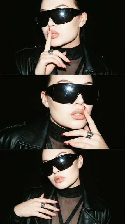 Ultra-realistic Y2K grunge fashion photo triptych, ONE image with 3 horizontal frames stacked vertically. Same woman, same outfit, same black background, photographed seconds apart.

Glossy nude-pink lips, slightly parted. Silver hoop/ear cuff. Oversized black leather jacket with strong shoulders and realistic textured leather. Underneath, semi-sheer black turtleneck top with horizontal strap details across the chest.

Long almond-shaped nails with nude base and sharp red French tips. Massive silver ring with dark stones.

FRAME 1: Medium close-up, body slightly turned, one hand raised to her face, index finger pressed vertically against her lips in a playful "shh" gesture. Head slightly tilted, lips slightly parted, confident expression.

FRAME 2: Closer portrait, finger still near lips, head turned slightly toward camera, glossy lips catching the flash. Leather jacket texture clearly visible.

FRAME 3: Slightly wider frame, body angled differently, hand lowering slightly from the face while maintaining the same bold attitude.

LIGHTING & STYLE: hard direct on-camera flash, strong glossy highlights on lips, skin and leather, deep black background, dramatic shadows, high contrast, subtle film grain, slight analog texture, muted dark colors, authentic late-1990s / early-2000s grunge fashion editorial.

Raw flash photography, disposable-camera / compact-camera feel, slightly imperfect exposure, subtle grain and softness, realistic skin pores and texture.

The result should feel like a rare Y2K fashion photo from an old magazine/editorial archive, edgy, cool, mysterious and effortlessly confident, not modern polished fashion photography.

Realistic anatomy, natural hands and fingers, accurate jewelry, realistic leather and fabric textures.

Очки: Огромные черные солнцезащитные очки-щитки с массивной оправой, полностью закрывающей глаза. Глубокие черные линзы и глянцевая черная оправа создают яркий футуристический образ в стиле 2000-х. Очки отражают яркий свет от прямой вспышки камеры и идеально вписываются в редакционный стиль гранжа конца 1990-х — начала 2000-х.