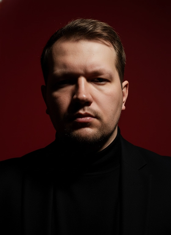 Создай портрет, используя те же черты лица (на основе загруженного фото), характеризующийся резким кинематографическим освещением и интенсивным контрастом. Снятый с немного нижнего ракурса, направленного вверх, что подчеркивает линию подбородка и шеи модели, этот портрет производит впечатление доминантности и скульптурной элегантности. Фон — глубокий, насыщенный малиново-красный, создающий яркий визуальный контраст со сияющей кожей модели и темной одеждой.