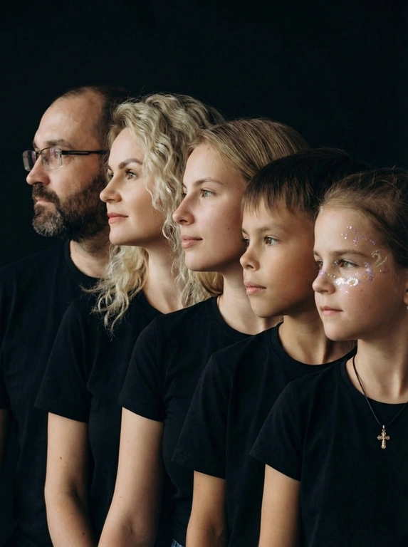 Профессиональный студийный портрет с низким контрастным светом. Головы расположены строго в одну линию. боковой профиль, взгляд влево. У всех видны только головы и немного плечи. Головы занимают весь кадр. Черный фон. Черная одежда у всех. Расположи их по убыванию возраста.