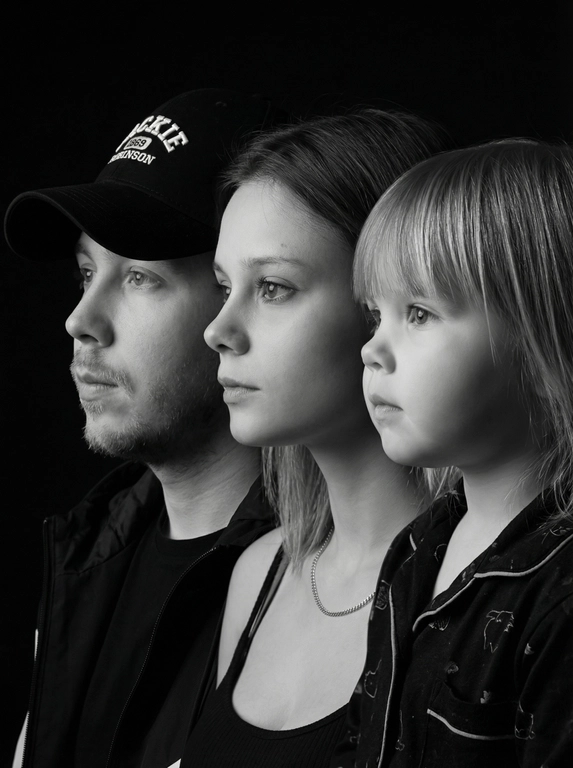 Профессиональный студийный портрет с низким контрастным светом. Головы расположены строго в одну линию. боковой профиль, взгляд влево. У всех видны только головы и немного плечи. Головы занимают весь кадр. Черный фон. Черная одежда у всех. Расположи их по убыванию возраста.