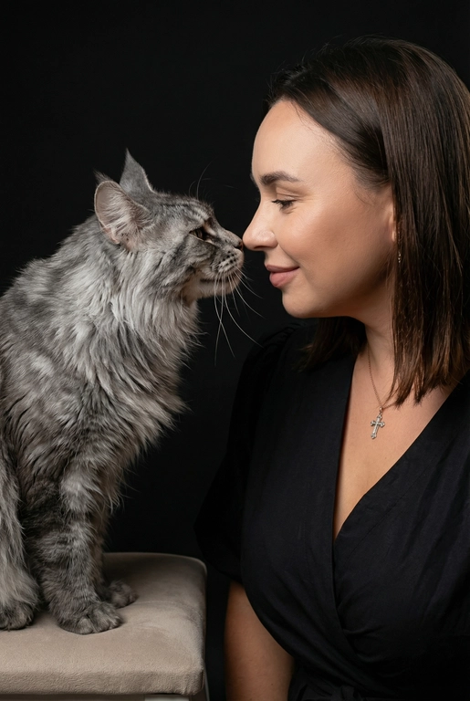 Сделай фото со мной и моим питомцем. Реалистичное фото, с высокой детализацией. Снимок меня и моего питомца в профиль. Фото сделано первым средним планом (Medium CloseUP), в кадре видно часть туловища (с головы до середины груди).
Я стою лицом к своему питомцу в строгий профиль, смотрю прямо на него.
Мой питомец расположен прямо напротив моего лица, также в профиль, смотрит прямо на меня. Наши носы почти соприкасаются. Наши головы могут быть наклонены: например, моя голова наклонена немного вниз, а голова питомца наоборот повыше. Четкая визуальная симметрия между моем лицом и головой моего питомца.
Студийное освещение, мягкий свет, создающий контрастность и скульптурные тени, на самом лице минимум тени. 


У меня легкая улыбка, питомец смотрит с дружелюбным настроем. Фон черный. 