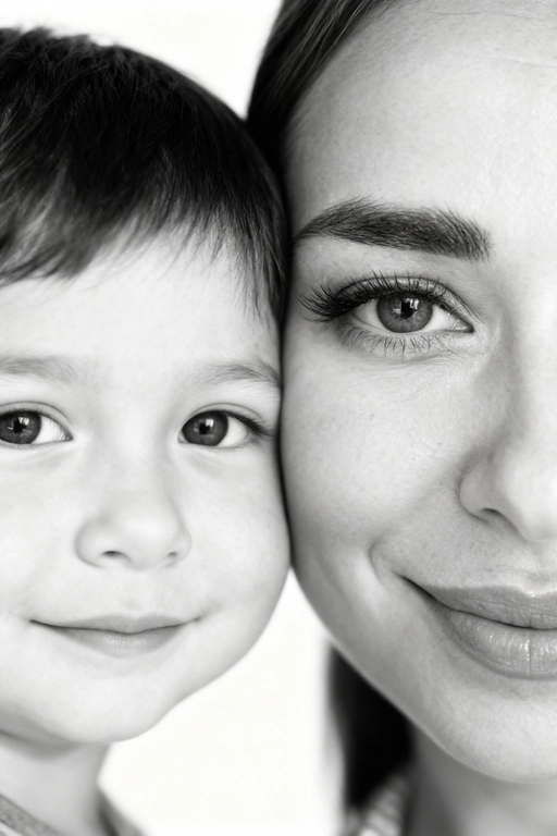 Сверхреалистичная черно-белая художественная фотография 8K женщины и ребенка, снятая очень крупным планом, щека к щеке так что видны только правая половина лица женщины и левая половина лица ребенка. которые смотрят в камеру. Их лица расположены рядом, почти соприкасаясь, образуя идеально сбалансированную симметричную композицию. Каждая деталь передана с фотографической точностью: тонкая текстура кожи и плавные градиенты света и тени. Видимая половина женщины включает ее бровь, один глаз , часть ее носа, щеку и губы, слегка приоткрытые в нежной, естественной улыбке, Видимая половина ребенка включает один глаз , круглую мягкую щеку, часть носа и небольшую улыбку, Фон белый и слегка размытый, что подчеркивает эмоциональную близость между ними. Освещение мягкое и рассеянное, создает деликатный контраст и тональную глубину. На снимке запечатлены нежность, близость и связь между матерью и ребенком, запечатленные с потрясающей реалистичностью. Не меняй черты лиц. 