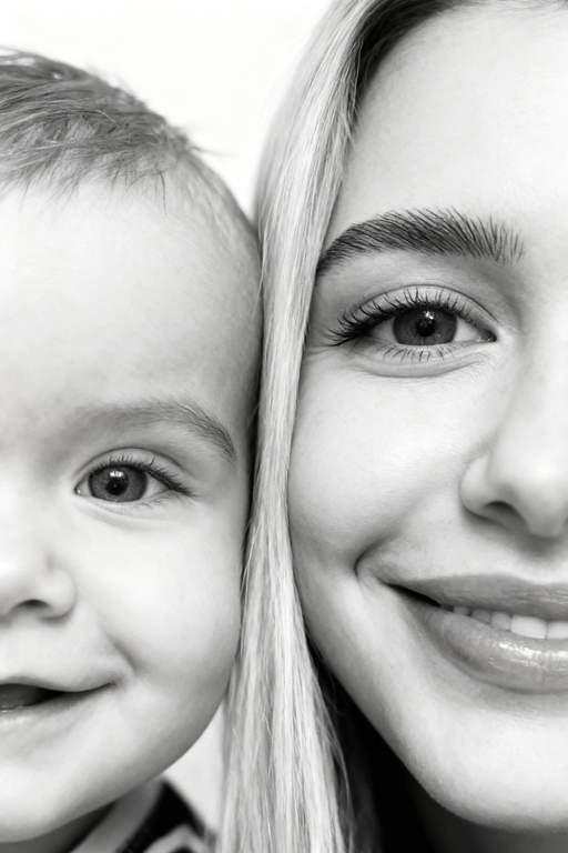 Сверхреалистичная черно-белая художественная фотография 8K женщины и ребенка, снятая очень крупным планом, щека к щеке так что видны только правая половина лица женщины и левая половина лица ребенка. которые смотрят в камеру. Их лица расположены рядом, почти соприкасаясь, образуя идеально сбалансированную симметричную композицию. Каждая деталь передана с фотографической точностью: тонкая текстура кожи и плавные градиенты света и тени. Видимая половина женщины включает ее бровь, один глаз , часть ее носа, щеку и губы, слегка приоткрытые в нежной, естественной улыбке, Видимая половина ребенка включает один глаз , круглую мягкую щеку, часть носа и небольшую улыбку, Фон белый и слегка размытый, что подчеркивает эмоциональную близость между ними. Освещение мягкое и рассеянное, создает деликатный контраст и тональную глубину. На снимке запечатлены нежность, близость и связь между матерью и ребенком, запечатленные с потрясающей реалистичностью. Не меняй черты лиц. 