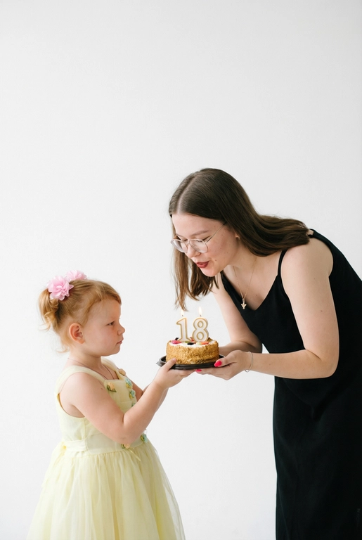 Фотореалистичный портрет в минималистичном стиле: на белом чистом фоне стоят взрослый человек и маленький ребёнок. Ребёнок держит торт и протягивает его взрослому человеку, чтобы он задул свечи с цифрой «». Фото выполнено с лёгкой зернистостью.
Атмосфера уюта, тишины и нежности. Высокая резкость, естественные пропорции, реалистичная фотография, художественный стиль.

18