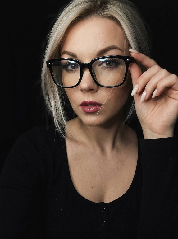 Максимально реалистичная фотография, темная винтажная эстетика в стиле dark glam glasses selfie, атмосферный ночной портрет.
Крупный портрет (Close-Up Portrait), кадр по грудь. Модель делает селфи, телефон не видно. Лицо занимает большую часть кадра, слегка повернуто вполоборота к камере. Голова немного наклонена. Взгляд направлен прямо в объектив, выражение спокойное, уверенное и притягательное. Губы слегка приоткрыты. Одна рука поднята к лицу и аккуратно касается оправы очков, словно поправляя их.
Макияж: Безупречный dark glam makeup. Ровный сияющий тон кожи, четко оформленные темные брови, длинные густые ресницы, тонкая стрелка, мягкий контуринг. Губы розово-винного оттенка с влажным глянцевым финишем.


Аксессуары: Крупные черные очки с прозрачными линзами и массивной квадратной оправой. На линзах заметны мягкие отражения света. Маленькие серьги-гвоздики. Длинный миндалевидный маникюр молочно-бежевого оттенка.

Одежда: Черный лонгслив с глубоким вырезом и небольшими пуговицами спереди. Темная ткань почти сливается с фоном, сохраняя видимую текстуру и силуэт.

Локация: Фон полностью черный.

Освещение: Мягкий приглушенный свет спереди и немного сбоку, словно от экрана телефона. Свет деликатно подсвечивает лицо, очки, губы, пальцы и ногти, оставляя волосы и одежду в глубоких тенях.

Камера: Реалистичное селфи высокого качества, RAW photo, натуральная перспектива смартфона, высокая детализация лица и аксессуаров.

Глубина резкости: Небольшая. Лицо, очки, губы и рука находятся в фокусе, фон растворяется в мягкой темноте.

Кожа: Реалистичная текстура кожи с видимыми порами, естественными переходами света и тени, без эффекта пластика и чрезмерной ретуши.

Детали: Блики на линзах очков, влажный блеск губ, отдельные волоски и пряди на лице, текстура ткани, отражения света на ногтях, легкое пленочное зерно.

Атмосфера: Загадочный ночной вайб, уверенность, женственность, винтажная эстетика, ощущение случайного красивого селфи в темноте.

Какая будет прическа?: Волосы перекинуты на одну сторону. Несколько тонких прядей проходят через щеку и губы, создавая живой эффект движения. Видна естественная текстура и мягкий блеск.
