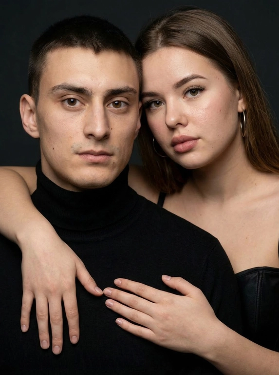 Гиперреалистичный студийный fashion-портрет молодой пары по загруженному референсу, 100% сходство лиц. Черты лица не изменять. Крупный план, кадр по плечи. Мужчина, спокойный уверенный взгляд прямо в камеру, естественное выражение лица, одет в черный трикотажный свитер с высоким воротом. Женщина стоит позади мужчины и нежно обнимает его, ее руки лежат на его плечах. Ее лицо расположено рядом с его лицом, она повернута слегка боком, голова немного наклонена вперед, взгляд направлен прямо в камеру. У женщины выразительные глаза с длинными густыми черными ресницами, естественный clean-glam макияж, натуральные брови, теплый оливковый оттенок кожи, небольшие серьги-кольца. Композиция плотная и интимная, их лица расположены очень близко друг к другу, современный модный портрет пары. Женщина одета в черный корсет. Кожа максимально натуральная: живая текстура кожи, видимые микропоры, subtle skin glow, естественный мягкий блеск кожи, natural skin microtexture, skin translucency, micro skin details, легкие естественные несовершенства кожи, без ретуши и без эффекта пластика. Освещение: мягкий студийный beauty lighting, рассеянный ключевой свет спереди и немного сбоку, мягкие глубокие тени для объема лица, деликатные световые блики на коже. Фон: глубокий темный студийный фон, темно-графитовый или почти черный, создающий контраст с кожей и лицами. Стиль: luxury fashion editorial photography, high fashion portrait, ultra photorealistic, 85mm portrait lens, shallow depth of field, creamy bokeh, cinematic soft lighting, RAW photo, extremely detailed, fine hair strands, natural skin pores, professional photography, photorealism, 8k, high dynamic range.