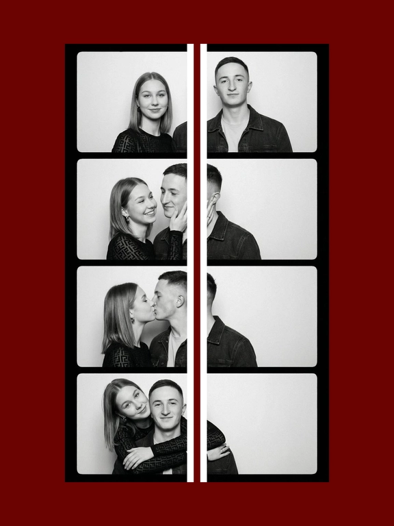 A black-and-white vertical vintage photobooth strip 1X4 of a man and a woman. The man wears a dark denim jacket over a light T-shirt. The woman wears a fitted semi-sheer black long-sleeve top with delicate small patterned details. Realistic candid couple energy, authentic photobooth snapshot feel, not too polished, not perfectly symmetrical, natural imperfect posing. All frames are stacked in a one column, one frame under another. Plain light studio background, strictly white photobooth borders with same width and square corners, realistic analog photobooth aesthetic, gentle film grain, soft contrast, natural skin texture, even frontal photobooth lighting. Frame 1: both stand side by side facing the camera, the woman on the left and the man on the right, slight height imbalance preserved, empty space between them, symmetrical centered composition. The woman's head slightly turned to the right, a flirtatious smile, a glance to the side. Frame 2: the woman turns toward the man and gently holds his cheek with one hand, smiling brightly; the man turns toward her with a soft smile. Their faces are close, but the composition remains off-center and slightly left-weighted, with more negative space on the right. Frame 3: the couple kiss in profile, the woman on the left and the man on the right, the couple is positioned close to the left side of the frame, extra empty space on the right side. The woman on his left, her hand on the men's cheek. Frame 4: the woman hugs the man from behind over his shoulders, her head leaning from the upper left side toward him, while the man faces the camera smiling. the couple is positioned very close to the left side of the frame, the right half of the frame is empty.