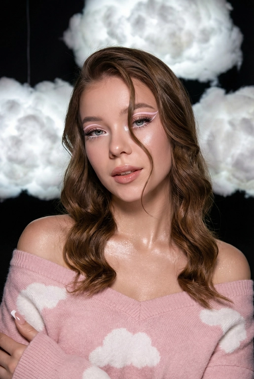 Крупный план лица девушки в стиле «высокой моды». Элегантный макияж глаза с длинными острыми нежно розовые двойные изогнутые стрелки, длинные густые ресницы эффект лучики, нижние густо ресницы накрашены белым и белый каял карандаш на нижнем веке белый Хайлайтер во внутренних уголках и скулах. Губы слегка приоткрыты в легкой ухмылке в легком блеске. Голова наклонена в сторону. На ней пушистый дорогой кашемировый нежно розовый свитер с белыми облаками плечи открыты.
За ней свисают объемные пушистые облака из ваты подсвеченные белым изнутри. Тело и декольте подсвечены хайлайтером и шиммером. Высокая детализация текстур кожи, одежды и волос. Черты лица-полностью сохранены как на референсном фото.
Ногти френч квадрат длинные.
На фоне светлая большая бьюти студия, вокруг темно, ее лицо освещено яркой лампой.  Волосы длинные до ключицы,коричневые волосы,блестящие прическа пляжные локоны. Локон волос падает на лицо 