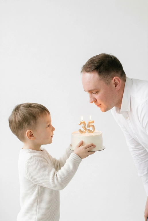 Фотореалистичный портрет в минималистичном стиле: на белом чистом фоне стоят взрослый человек и маленький ребёнок. Ребёнок держит торт и протягивает его взрослому человеку, чтобы он задул свечи с цифрой «». Фото выполнено с лёгкой зернистостью.
Атмосфера уюта, тишины и нежности. Высокая резкость, естественные пропорции, реалистичная фотография, художественный стиль.

Цифра на торте:  35