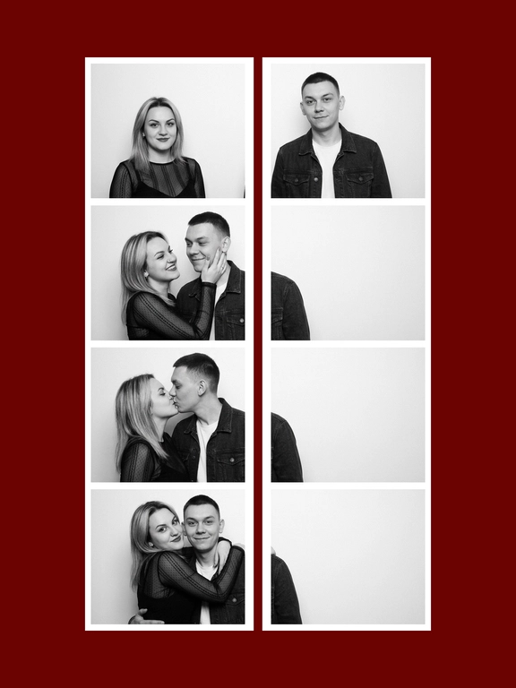 A black-and-white vertical vintage photobooth strip 1X4 of a man and a woman. The man wears a dark denim jacket over a light T-shirt. The woman wears a fitted semi-sheer black long-sleeve top with delicate small patterned details. Realistic candid couple energy, authentic photobooth snapshot feel, not too polished, not perfectly symmetrical, natural imperfect posing. All frames are stacked in a one column, one frame under another. Plain light studio background, strictly white photobooth borders with same width and square corners, realistic analog photobooth aesthetic, gentle film grain, soft contrast, natural skin texture, even frontal photobooth lighting. Frame 1: both stand side by side facing the camera, the woman on the left and the man on the right, slight height imbalance preserved, empty space between them, symmetrical centered composition. The woman's head slightly turned to the right, a flirtatious smile, a glance to the side. Frame 2: the woman turns toward the man and gently holds his cheek with one hand, smiling brightly; the man turns toward her with a soft smile. Their faces are close, but the composition remains off-center and slightly left-weighted, with more negative space on the right. Frame 3: the couple kiss in profile, the woman on the left and the man on the right, the couple is positioned close to the left side of the frame, extra empty space on the right side. The woman on his left, her hand on the men's cheek. Frame 4: the woman hugs the man from behind over his shoulders, her head leaning from the upper left side toward him, while the man faces the camera smiling. the couple is positioned very close to the left side of the frame, the right half of the frame is empty.
