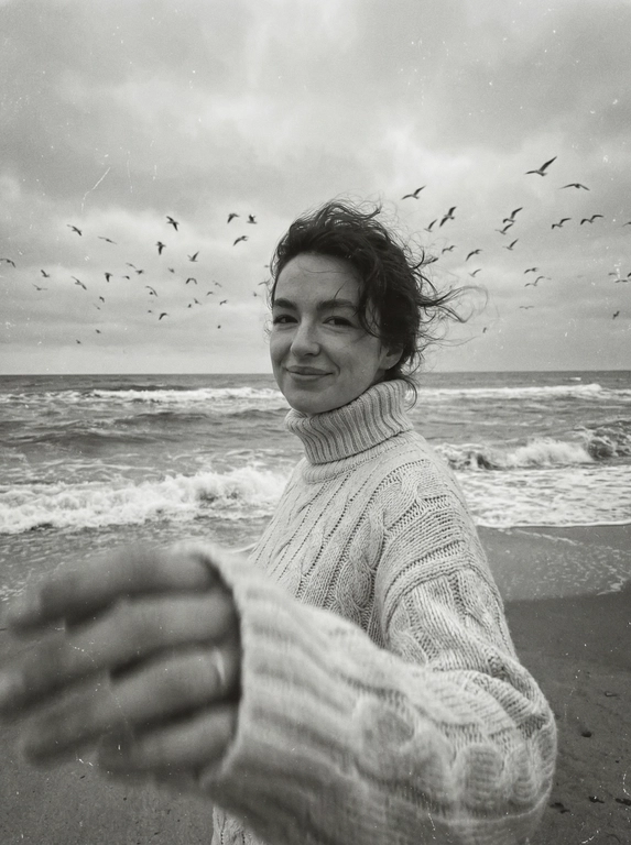Создай портрет, не меняя черты лица. Черно-белая фотография в стиле ретро: человек стоит на морском побережье, в полупрофиль, смотрит нежно в камеру, легкая улыбка на лице, одет(а) в светлый оверсайз вязаный свитер с высоким воротником. На переднем плане — размытая рука в движении (motion blur), на заднем плане — море с волнами и стая птиц в небе, пасмурное небо. Сильная зернистость пленки, винтажная эстетика, атмосфера свободы, эффект размытия в движении, эстетика.



