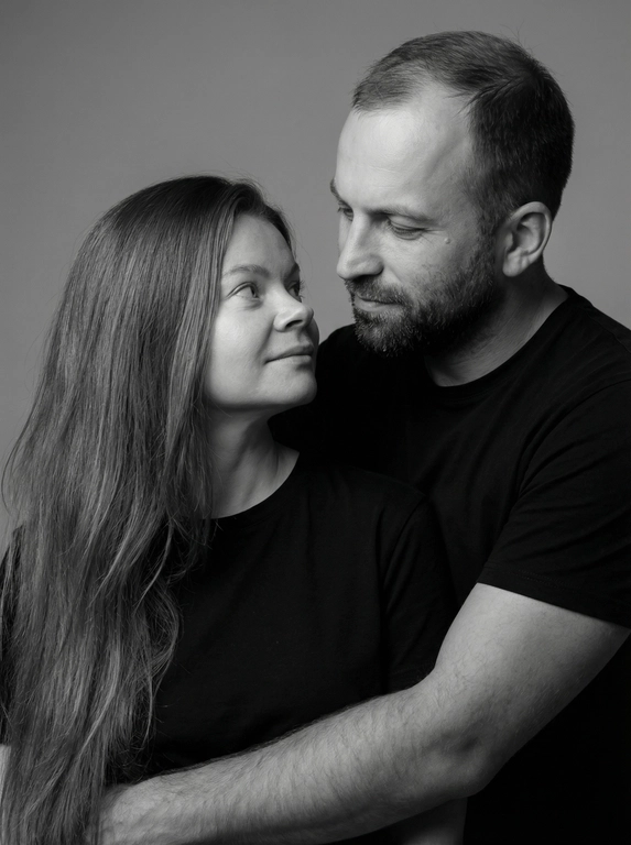   Сделай двоим семейную фотосессию. Любящий муж с любящей женой. Фото портретное в студии в черно белом стиле. Муж и жена одеты в рубашки подходящие по стилю и цвету друг другу. Мягкий свет который подчеркивает их любовь