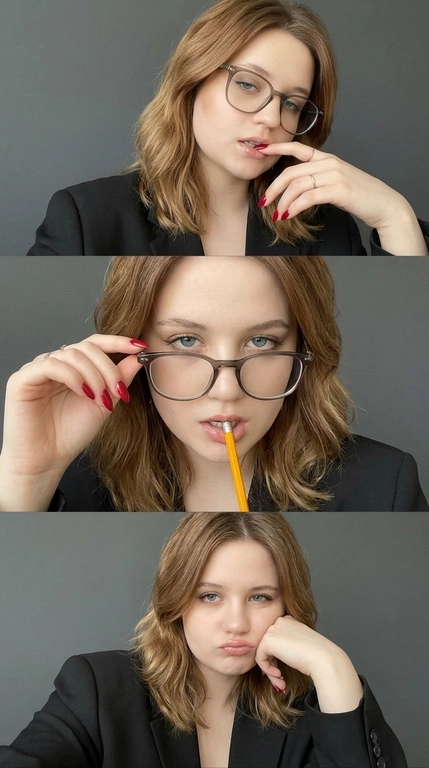 Вертикальный коллаж из трёх фотореалистичных селфи, снятых на фронтальную камеру телефона в одном и том же положении. Камера на уровне лица, крупный план по грудь. Композиция состоит из трёх горизонтальных кадров, расположенных один под другим.

Во всех трёх кадрах женщина сидит за столом, слегка наклонившись к камере. На ней чёрный строгий пиджак oversize с широкими лацканами, под ним детали одежды практически не видны. Руки постоянно находятся в кадре и создают игривое, кокетливое настроение. На ногтях яркий глянцевый маникюр насыщенного красного цвета, средняя длина, миндалевидная форма. На пальцах тонкие минималистичные кольца.

Первый верхний кадр: голова слегка наклонена вправо, лицо частично закрыто крупными очками с толстой оправой, на линзах мягкие блики. Женщина слегка прикусывает нижнюю губу и касается кончиком пальца губ. Взгляд направлен вниз, глаза почти не видны.

Второй центральный кадр: камера расположена немного ближе, основной акцент на глазах и губах. Очки те же, слегка опущены на переносицу, глаза полностью видны. Взгляд прямой, интенсивный, немного снизу вверх. В руке жёлтый карандаш, поднесённый к губам и слегка зажатый между приоткрытыми губами.

Третий нижний кадр: камера немного дальше, видна верхняя часть торса и большая часть пиджака. Женщина опирается щекой на кулак, локоть стоит на столе, голова слегка наклонена. Губы немного надуты, выражение капризное и игривое. Очки остаются на лице, линзы слегка бликуют, глаза частично прикрыты.

Макияж во всех трёх кадрах одинаковый: естественная кожа с лёгким сиянием, мягкий скульптуринг щёк и тёплый румянец. Нейтральные тени, тонкая чёрная стрелка по верхнему веку, удлинённые ресницы с акцентом на внешний уголок. Брови аккуратно уложены и оформлены. Губы с насыщенным бежево-розовым или нюдовым глянцем и мягким чётким контуром.

Фон во всех трёх кадрах одинаковый: ровная тёмно-серая графитовая стена без деталей, слегка размытая. Освещение мягкое и рассеянное, похожее на естественный дневной офисный свет сверху и спереди, без жёстких теней. Свет деликатно подсвечивает лицо и придаёт коже натуральное сияние.

Нейтральная цветопередача, минимальная цифровая обработка, лёгкий естественный глянец, реалистичная текстура кожи, чистая эстетика живого телефонного селфи, без пластиковой ретуши и без AI-эффекта.

Причёска: Волосы уложены в крупные мягкие локоны с естественным объёмом и лёгким глянцевым блеском. Локоны свободно обрамляют лицо и мягко ложатся по плечам, создавая ухоженный, выразительный образ.