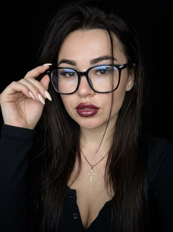 Максимально реалистичная фотография, темная винтажная эстетика в стиле dark glam glasses selfie, атмосферный ночной портрет.
Крупный портрет (Close-Up Portrait), кадр по грудь. Модель делает селфи, телефон не видно. Лицо занимает большую часть кадра, слегка повернуто вполоборота к камере. Голова немного наклонена. Взгляд направлен прямо в объектив, выражение спокойное, уверенное и притягательное. Губы слегка приоткрыты. Одна рука поднята к лицу и аккуратно касается оправы очков, словно поправляя их.
Макияж: Безупречный dark glam makeup. Ровный сияющий тон кожи, четко оформленные темные брови, длинные густые ресницы, тонкая стрелка, мягкий контуринг. Губы розово-винного оттенка с влажным глянцевым финишем.


Аксессуары: Крупные черные очки с прозрачными линзами и массивной квадратной оправой. На линзах заметны мягкие отражения света. Маленькие серьги-гвоздики. Длинный миндалевидный маникюр молочно-бежевого оттенка.

Одежда: Черный лонгслив с глубоким вырезом и небольшими пуговицами спереди. Темная ткань почти сливается с фоном, сохраняя видимую текстуру и силуэт.

Локация: Фон полностью черный.

Освещение: Мягкий приглушенный свет спереди и немного сбоку, словно от экрана телефона. Свет деликатно подсвечивает лицо, очки, губы, пальцы и ногти, оставляя волосы и одежду в глубоких тенях.

Камера: Реалистичное селфи высокого качества, RAW photo, натуральная перспектива смартфона, высокая детализация лица и аксессуаров.

Глубина резкости: Небольшая. Лицо, очки, губы и рука находятся в фокусе, фон растворяется в мягкой темноте.

Кожа: Реалистичная текстура кожи с видимыми порами, естественными переходами света и тени, без эффекта пластика и чрезмерной ретуши.

Детали: Блики на линзах очков, влажный блеск губ, отдельные волоски и пряди на лице, текстура ткани, отражения света на ногтях, легкое пленочное зерно.

Атмосфера: Загадочный ночной вайб, уверенность, женственность, винтажная эстетика, ощущение случайного красивого селфи в темноте.

Какая будет прическа?: Волосы выглядят естественно и растрёпанно, с мягкой текстурой и свободными прядями у лица. Создаёт эффект живого, случайного и стильного кадра, без ощущения идеальной салонной укладки.
