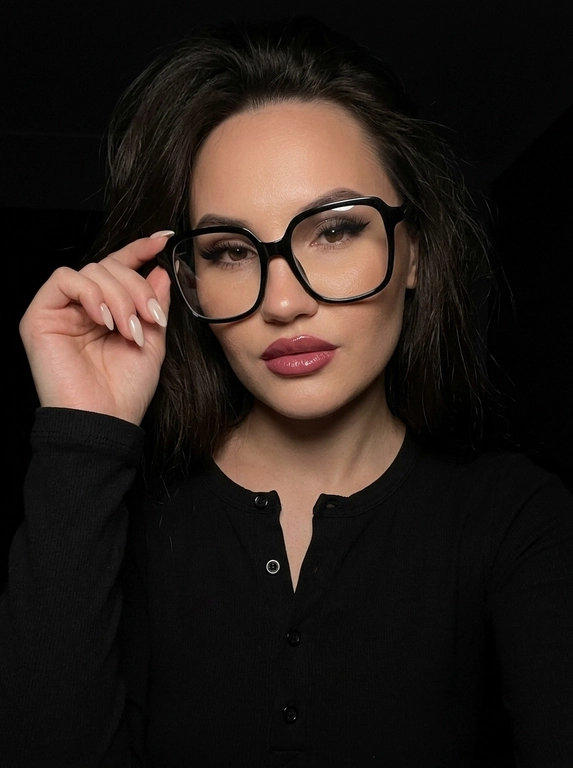 Максимально реалистичная фотография, темная винтажная эстетика в стиле dark glam glasses selfie, атмосферный ночной портрет.
Крупный портрет (Close-Up Portrait), кадр по грудь. Модель делает селфи, телефон не видно. Лицо занимает большую часть кадра, слегка повернуто вполоборота к камере. Голова немного наклонена. Взгляд направлен прямо в объектив, выражение спокойное, уверенное и притягательное. Губы слегка приоткрыты. Одна рука поднята к лицу и аккуратно касается оправы очков, словно поправляя их.
Макияж: Безупречный dark glam makeup. Ровный сияющий тон кожи, четко оформленные темные брови, длинные густые ресницы, тонкая стрелка, мягкий контуринг. Губы розово-винного оттенка с влажным глянцевым финишем.


Аксессуары: Крупные черные очки с прозрачными линзами и массивной квадратной оправой. На линзах заметны мягкие отражения света. Маленькие серьги-гвоздики. Длинный миндалевидный маникюр молочно-бежевого оттенка.

Одежда: Черный лонгслив с глубоким вырезом и небольшими пуговицами спереди. Темная ткань почти сливается с фоном, сохраняя видимую текстуру и силуэт.

Локация: Фон полностью черный.

Освещение: Мягкий приглушенный свет спереди и немного сбоку, словно от экрана телефона. Свет деликатно подсвечивает лицо, очки, губы, пальцы и ногти, оставляя волосы и одежду в глубоких тенях.

Камера: Реалистичное селфи высокого качества, RAW photo, натуральная перспектива смартфона, высокая детализация лица и аксессуаров.

Глубина резкости: Небольшая. Лицо, очки, губы и рука находятся в фокусе, фон растворяется в мягкой темноте.

Кожа: Реалистичная текстура кожи с видимыми порами, естественными переходами света и тени, без эффекта пластика и чрезмерной ретуши.

Детали: Блики на линзах очков, влажный блеск губ, отдельные волоски и пряди на лице, текстура ткани, отражения света на ногтях, легкое пленочное зерно.

Атмосфера: Загадочный ночной вайб, уверенность, женственность, винтажная эстетика, ощущение случайного красивого селфи в темноте.

Какая будет прическа?: Волосы выглядят естественно и растрёпанно, с мягкой текстурой и свободными прядями у лица. Создаёт эффект живого, случайного и стильного кадра, без ощущения идеальной салонной укладки.