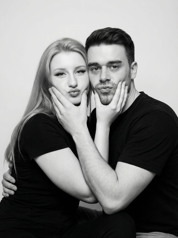   Чёрно-белый студийный портрет молодой пары, мы нанейтральном светлом фоне. Мы сидим очень близко друг к другу, слегка повернувшись к камере. Мы обнимаемся, прижавшись плечами, и одновременно держим ладонями лица друг друга, сжимая щёки, создавая забавное «утиное» выражение губ. Настроение игривое и теплое. Оба одеты в простую тёмную одежду без принтов.минимализм в стиле. Мягкий студийный свет, равномерное освещение без жёстких теней, высокая детализация кожи и ВОЛОС.