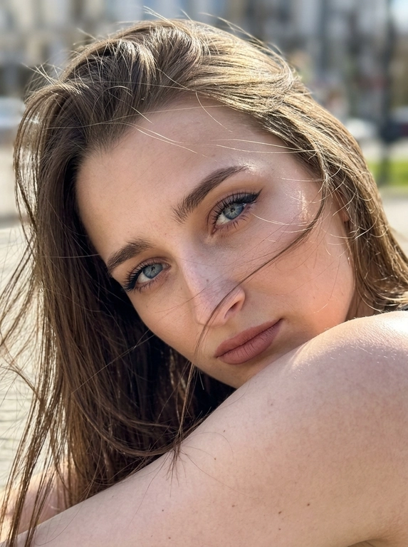 Ультрареалистичная фотография, случайный живой портрет, снятый на iPhone 17 Pro. Эффект настоящего кадра, сделанного в моменте, без постановочности, без фильтров и ретуши.

Внешность полностью сохранена без изменений. Женщина смотрит прямо в камеру. Голова слегка наклонена в сторону и опирается на плечо, плечо частично закрывает лицо. Выражение загадочное, притягательное и естественное.
Волосы активно развеваются ветром, отдельные пряди частично закрывают лицо и глаза, создавая эффект живого случайного кадра. Максимальная детализация отдельных волосков.

Легкий макияж с акцентом на глаза: длинные объемные ресницы, стрелки cat-eye на верхнем веке, идеально оформленные брови. Нюдовая матовая помада оттенка пыльной розы с контуром на тон темнее, влажный хайлайтер на скулах и переносице.

Одежда не видна. Основной акцент на лице, глазах и волосах.

Яркий прямой солнечный свет падает под углом на лицо, интенсивно подсвечивая глаза, подчеркивая глубину радужки, длинные ресницы и естественные блики в глазах. Солнечные лучи создают красивые световые акценты в волосах и на коже.

Естественная текстура кожи с видимыми порами, микрорельефом, легкими несовершенствами, едва заметными капиллярами в глазах. Живая кожа без эффекта пластика. Легкий цифровой шум, характерный для реальной фотографии.

Shot on iPhone 17 Pro, natural light, candid portrait, hyper detailed iris, visible skin pores, realistic skin texture, unedited RAW photo, depth of field, soft highlights, windblown hair, authentic photography, photorealistic, ultra realistic, 8k.