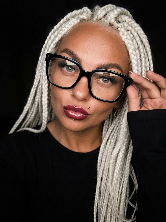 Максимально реалистичная фотография, темная винтажная эстетика в стиле dark glam glasses selfie, атмосферный ночной портрет.
Крупный портрет (Close-Up Portrait), кадр по грудь. Модель делает селфи, телефон не видно. Лицо занимает большую часть кадра, слегка повернуто вполоборота к камере. Голова немного наклонена. Взгляд направлен прямо в объектив, выражение спокойное, уверенное и притягательное. Губы слегка приоткрыты. Одна рука поднята к лицу и аккуратно касается оправы очков, словно поправляя их.
Макияж: Безупречный dark glam makeup. Ровный сияющий тон кожи, четко оформленные темные брови, длинные густые ресницы, тонкая стрелка, мягкий контуринг. Губы розово-винного оттенка с влажным глянцевым финишем.


Аксессуары: Крупные черные очки с прозрачными линзами и массивной квадратной оправой. На линзах заметны мягкие отражения света. Маленькие серьги-гвоздики. Длинный миндалевидный маникюр молочно-бежевого оттенка.

Одежда: Черный лонгслив с глубоким вырезом и небольшими пуговицами спереди. Темная ткань почти сливается с фоном, сохраняя видимую текстуру и силуэт.

Локация: Фон полностью черный.

Освещение: Мягкий приглушенный свет спереди и немного сбоку, словно от экрана телефона. Свет деликатно подсвечивает лицо, очки, губы, пальцы и ногти, оставляя волосы и одежду в глубоких тенях.

Камера: Реалистичное селфи высокого качества, RAW photo, натуральная перспектива смартфона, высокая детализация лица и аксессуаров.

Глубина резкости: Небольшая. Лицо, очки, губы и рука находятся в фокусе, фон растворяется в мягкой темноте.

Кожа: Реалистичная текстура кожи с видимыми порами, естественными переходами света и тени, без эффекта пластика и чрезмерной ретуши.

Детали: Блики на линзах очков, влажный блеск губ, отдельные волоски и пряди на лице, текстура ткани, отражения света на ногтях, легкое пленочное зерно.

Атмосфера: Загадочный ночной вайб, уверенность, женственность, винтажная эстетика, ощущение случайного красивого селфи в темноте.

Какая будет прическа?: Не менять мою прическу