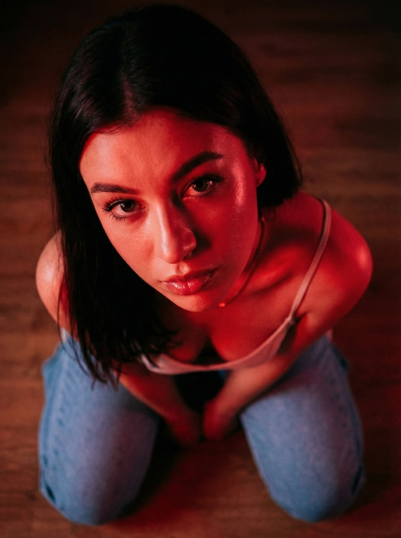   
 Создай портрет, не меняя черты лица.Крупный
 план молодой женщины, она сидит на полу на 
коленях , смотрит  прямо в камеру , ракурс
 съемки свеерху. безупречный макияж. 
Интеенсивное красное неоновое освещение,
 создающее глубокие тени и яркие блики на коже.
 У девушки  темные волосы, Она одета в светлый 
 топ на тонких бретелях. И голубые джинсы. Она сидит на коленях , голову
 запрокинула  и смотрит в камеру . Атмосфера
таинственная, кинематографичная, высокая 
 контрастность, гиперреализм, детализация кожи
8k.
 эстетика нуар, роковой взгляд, влажный блеск на
 губах, кинематографичный свет, 35мм объеектив,
f/ 1.8-ar 9:16 -v6.0
 Высокий контраст, зернистость пленки, интимная
 и напряженная атмосфера.