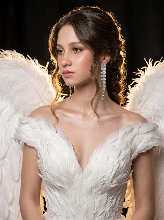 Создай реалистичный fashion-портрет, не меняя черты лица, возраст и телосложение. 
 
Макияж luxury beauty: ухоженная увлажнённая кожа с сатиновым свечением, лёгкий контуринг, персиково-розовые румяна высоко на скулах, влажный хайлайтер на скулах и ключицах. Брови пушистые, уложенные. На веках тёплые бежево-коричневые тени с затемнением внешнего угла, без стрелок. Ресницы длинные, разделённые. Губы розово-бежевые, сатиновый финиш. 
 
Платье: белое couture, кадр до линии талии. Глубокий V-образный лиф целиком собран из тончайших белых перьев, уложенных слоями в разных направлениях — объёмная скульптурная текстура, напоминающая крыло птицы. Плечи открыты. За плечами большие белые крылья из длинных страусиных перьев: основание скрыто за спиной, крылья раскрываются по обе стороны, верхняя часть в кадре, остальное уходит за границы. Перья с натуральной текстурой, без пластикового блеска. Серьги — длинные серебристые каскады до середины шеи из плотно посаженных прозрачных кристаллов. 
 
Поза: корпус под 45° к камере, голова в 3/4, подбородок слегка опущен, взгляд вдаль за кадр. Выражение спокойное, задумчивое. Шея вытянута, плечи расслаблены. 
 
Свет: тёплый контровой свет сзади создаёт светящийся ореол на волосах и перьях, слабый заполняющий с противоположной стороны. Контровой прорисовывает каждое перо. Фон тёмный, размытый. 
 
Luxury fashion editorial, Vogue, 85–105 мм, малая глубина резкости, мягкое боке, реалистичная текстура кожи, объёмный свет.

Какая будет прическа?: Объёмная вечерняя укладка с волнистой естественной текстурой. Передняя часть волос мягко убрана назад без гладкого зачёса, по бокам лица выпущены длинные волнистые пряди. Волосы уходят в объемную косу за спиной.