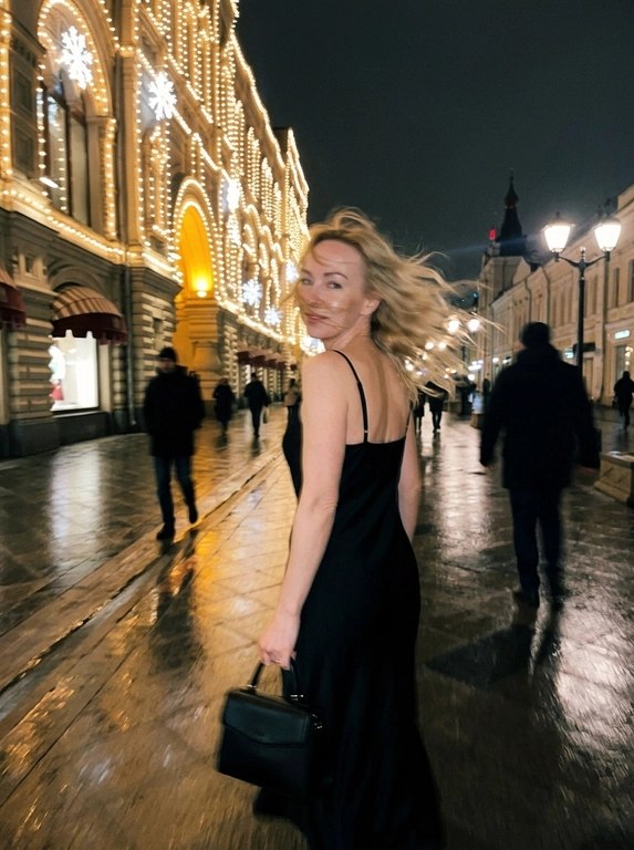 Девушка ночью на Никольской улице у фасада ГУМа