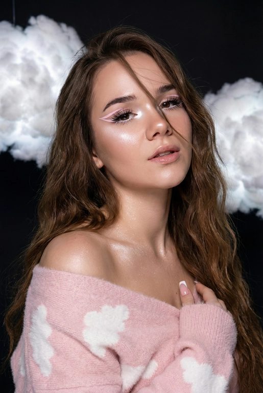 Крупный план лица девушки в стиле «высокой моды». Элегантный макияж глаза с длинными острыми нежно розовые двойные изогнутые стрелки, длинные густые ресницы эффект лучики, нижние густо ресницы накрашены белым и белый каял карандаш на нижнем веке белый Хайлайтер во внутренних уголках и скулах. Губы слегка приоткрыты в легкой ухмылке в легком блеске. Голова наклонена в сторону. На ней пушистый дорогой кашемировый нежно розовый свитер с белыми облаками плечи открыты.
За ней свисают объемные пушистые облака из ваты подсвеченные белым изнутри. Тело и декольте подсвечены хайлайтером и шиммером. Высокая детализация текстур кожи, одежды и волос. Черты лица-полностью сохранены как на референсном фото.
Ногти френч квадрат длинные.
На фоне светлая большая бьюти студия, вокруг темно, ее лицо освещено яркой лампой.  Волосы очень длинные блестящие прическа пляжные локоны. Локон волос падает на лицо 