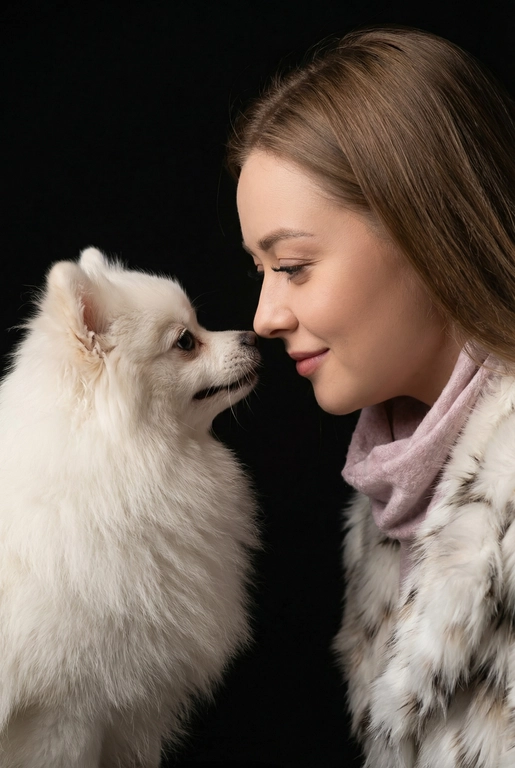 Сделай фото со мной и моим питомцем. Реалистичное фото, с высокой детализацией. Снимок меня и моего питомца в профиль. Фото сделано первым средним планом (Medium CloseUP), в кадре видно часть туловища (с головы до середины груди).
Я стою лицом к своему питомцу в строгий профиль, смотрю прямо на него.
Мой питомец расположен прямо напротив моего лица, также в профиль, смотрит прямо на меня. Наши носы почти соприкасаются. Наши головы могут быть наклонены: например, моя голова наклонена немного вниз, а голова питомца наоборот повыше. Четкая визуальная симметрия между моем лицом и головой моего питомца.
Студийное освещение, мягкий свет, создающий контрастность и скульптурные тени, на самом лице минимум тени. 
 У меня легкая улыбка, питомец смотрит с дружелюбным настроем. Фон черный. 