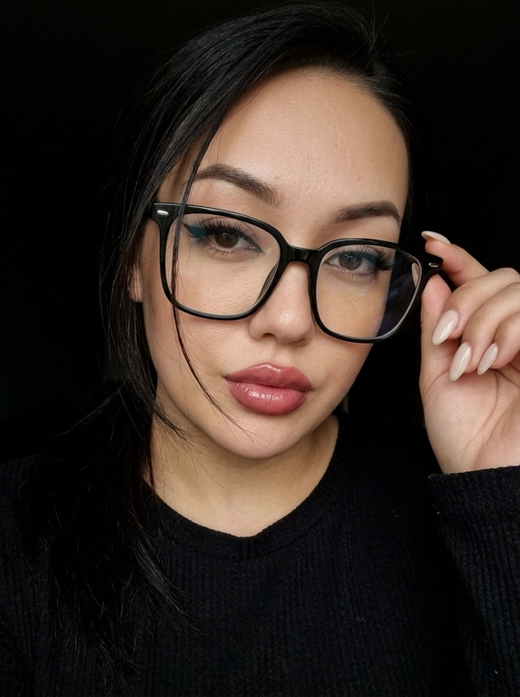 Максимально реалистичная фотография, темная винтажная эстетика в стиле dark glam glasses selfie, атмосферный ночной портрет.
Крупный портрет (Close-Up Portrait), кадр по грудь. Модель делает селфи, телефон не видно. Лицо занимает большую часть кадра, слегка повернуто вполоборота к камере. Голова немного наклонена. Взгляд направлен прямо в объектив, выражение спокойное, уверенное и притягательное. Губы слегка приоткрыты. Одна рука поднята к лицу и аккуратно касается оправы очков, словно поправляя их.
Макияж: Безупречный dark glam makeup. Ровный сияющий тон кожи, четко оформленные темные брови, длинные густые ресницы, тонкая стрелка, мягкий контуринг. Губы розово-винного оттенка с влажным глянцевым финишем.


Аксессуары: Крупные черные очки с прозрачными линзами и массивной квадратной оправой. На линзах заметны мягкие отражения света. Маленькие серьги-гвоздики. Длинный миндалевидный маникюр молочно-бежевого оттенка.

Одежда: Черный лонгслив с глубоким вырезом и небольшими пуговицами спереди. Темная ткань почти сливается с фоном, сохраняя видимую текстуру и силуэт.

Локация: Фон полностью черный.

Освещение: Мягкий приглушенный свет спереди и немного сбоку, словно от экрана телефона. Свет деликатно подсвечивает лицо, очки, губы, пальцы и ногти, оставляя волосы и одежду в глубоких тенях.

Камера: Реалистичное селфи высокого качества, RAW photo, натуральная перспектива смартфона, высокая детализация лица и аксессуаров.

Глубина резкости: Небольшая. Лицо, очки, губы и рука находятся в фокусе, фон растворяется в мягкой темноте.

Кожа: Реалистичная текстура кожи с видимыми порами, естественными переходами света и тени, без эффекта пластика и чрезмерной ретуши.

Детали: Блики на линзах очков, влажный блеск губ, отдельные волоски и пряди на лице, текстура ткани, отражения света на ногтях, легкое пленочное зерно.

Атмосфера: Загадочный ночной вайб, уверенность, женственность, винтажная эстетика, ощущение случайного красивого селфи в темноте.

Какая будет прическа?: Волосы перекинуты на одну сторону. Несколько тонких прядей проходят через щеку и губы, создавая живой эффект движения. Видна естественная текстура и мягкий блеск.
