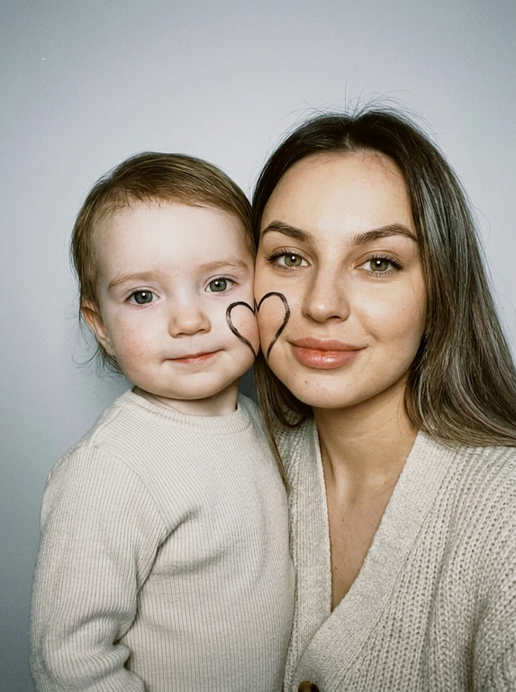 Не меняй внешность и черты лица «вертикальная фотография, мягкий студийный свет с эффектом вспышки, крупный план, умеренный контраст, лёгкая плёночная зернистость, винтажный документальный стиль.
Минималистичный светлый фон (чистая стена). Щёки людей соприкасаются. На щеке первого человека (слева) — половина сердца, на щеке второго человека (справа) — вторая, вместе образуют одно сердце.
Оба смотрят в камеру: у моделей спокойная теплая улыбка. 


Какая будет одежда?: Естественный внешний вид, уютная светлая повседневная одежда.