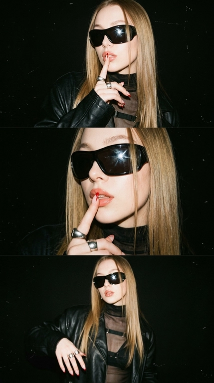 Ultra-realistic Y2K grunge fashion photo triptych, ONE image with 3 horizontal frames stacked vertically. Same woman, same outfit, same black background, photographed seconds apart.

Glossy nude-pink lips, slightly parted. Silver hoop/ear cuff. Oversized black leather jacket with strong shoulders and realistic textured leather. Underneath, semi-sheer black turtleneck top with horizontal strap details across the chest.

Long almond-shaped nails with nude base and sharp red French tips. Massive silver ring with dark stones.

FRAME 1: Medium close-up, body slightly turned, one hand raised to her face, index finger pressed vertically against her lips in a playful "shh" gesture. Head slightly tilted, lips slightly parted, confident expression.

FRAME 2: Closer portrait, finger still near lips, head turned slightly toward camera, glossy lips catching the flash. Leather jacket texture clearly visible.

FRAME 3: Slightly wider frame, body angled differently, hand lowering slightly from the face while maintaining the same bold attitude.

LIGHTING & STYLE: hard direct on-camera flash, strong glossy highlights on lips, skin and leather, deep black background, dramatic shadows, high contrast, subtle film grain, slight analog texture, muted dark colors, authentic late-1990s / early-2000s grunge fashion editorial.

Raw flash photography, disposable-camera / compact-camera feel, slightly imperfect exposure, subtle grain and softness, realistic skin pores and texture.

The result should feel like a rare Y2K fashion photo from an old magazine/editorial archive, edgy, cool, mysterious and effortlessly confident, not modern polished fashion photography.

Realistic anatomy, natural hands and fingers, accurate jewelry, realistic leather and fabric textures.

Очки: Огромные черные солнцезащитные очки-щитки с массивной оправой, полностью закрывающей глаза. Глубокие черные линзы и глянцевая черная оправа создают яркий футуристический образ в стиле 2000-х. Очки отражают яркий свет от прямой вспышки камеры и идеально вписываются в редакционный стиль гранжа конца 1990-х — начала 2000-х.