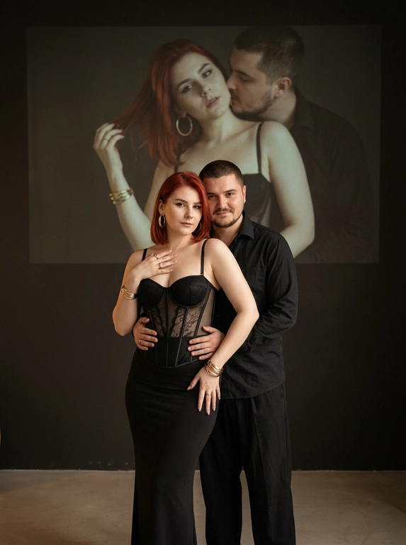 Создай, не меняя черты лица. фотография мужчины и женщины в элегантной позе. Она одета в обтягивающий корсет с прозрачными элементами и длинную, облегающую черную юбку. Мужчина стоит немного позади обнимает ее за талию, смотрит в камеру. Одна из ее рук касается области груди, в то время как другая слегка находится на бедрах, что создает динамичную позу. Она выглядит уверенно и привлекательно.
Она носит массивные золотые серьги. На руках золотые браслеты и кольца . Мужчина в черной рубашке и свободных брюках. Они покрывает меньшую часть Фон темный и минималистичный, в верхней части изображения есть мягкая и тусклая проекция одной и той же пары (в другой позе).
Естественная цветовая проекция мужчины и женщины занимает большую часть верхней части изображения и выглядит значительно больше. У нее соблазнительный взгляд, держа волосы одной рукой, и соблазнительно смотрит. Он целует ее в шею. Максимальная / детализация.

Доп. характеристики: У девушки волосы рыжей красные по плечи