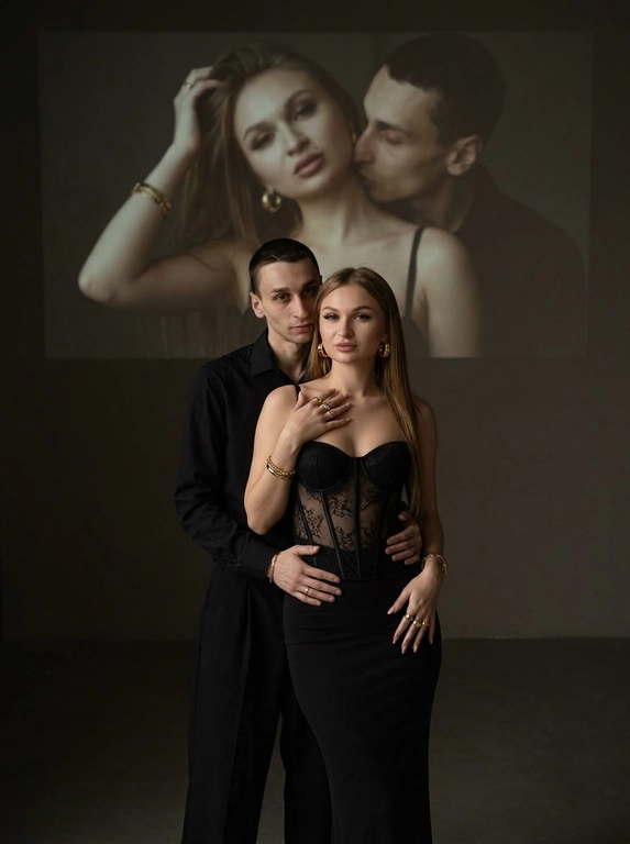 Создай, не меняя черты лица. фотография мужчины и женщины в элегантной позе. Она одета в обтягивающий корсет с прозрачными элементами и длинную, облегающую черную юбку. Мужчина стоит немного позади обнимает ее за талию, смотрит в камеру. Одна из ее рук касается области груди, в то время как другая слегка находится на бедрах, что создает динамичную позу. Она выглядит уверенно и привлекательно.
Она носит массивные золотые серьги. На руках золотые браслеты и кольца . Мужчина в черной рубашке и свободных брюках. Они покрывает меньшую часть Фон темный и минималистичный, в верхней части изображения есть мягкая и тусклая проекция одной и той же пары (в другой позе).
Естественная цветовая проекция мужчины и женщины занимает большую часть верхней части изображения и выглядит значительно больше. У нее соблазнительный взгляд, держа волосы одной рукой, и соблазнительно смотрит. Он целует ее в шею. Максимальная / детализация.