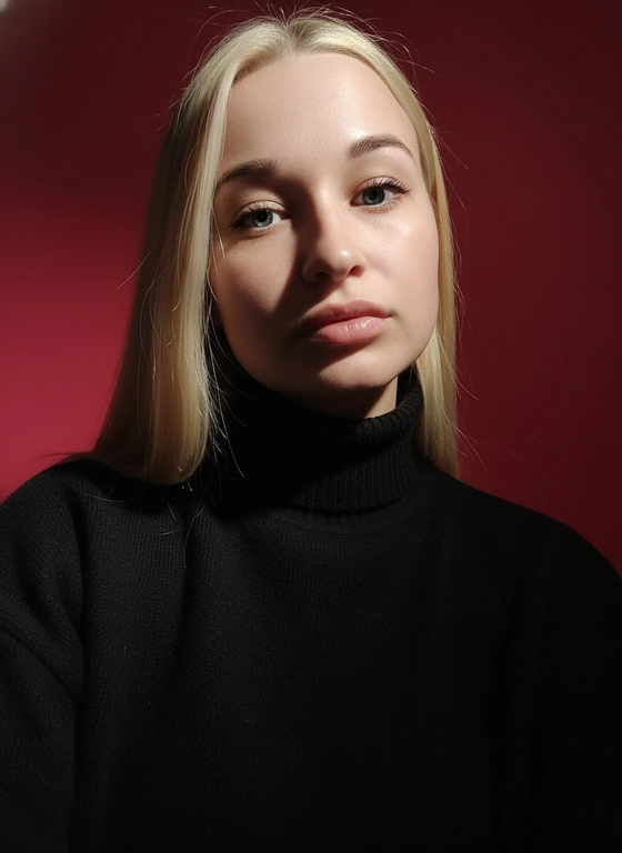 Создай портрет, используя те же черты лица (на основе загруженного фото), характеризующийся резким кинематографическим освещением и интенсивным контрастом. Снятый с немного нижнего ракурса, направленного вверх, что подчеркивает линию подбородка и шеи модели, этот портрет производит впечатление доминантности и скульптурной элегантности. Фон — глубокий, насыщенный малиново-красный, создающий яркий визуальный контраст со сияющей кожей модели и темной одеждой.